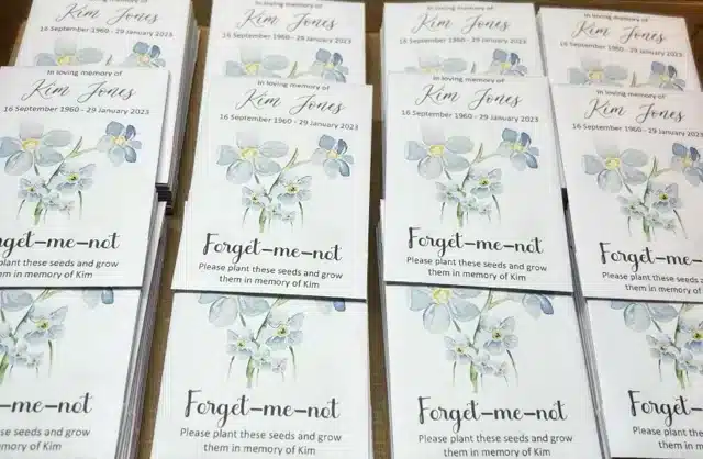 Gentle flat lay of eco friendly funeral seed packets with Forget Me Not watercolour design